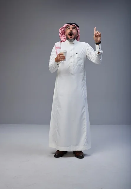 رجل سعودي بالزي التقليدي يشير للأعلى بذهول