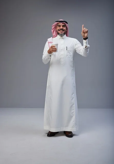 Saudi man in traditional attire holding a coffee cup