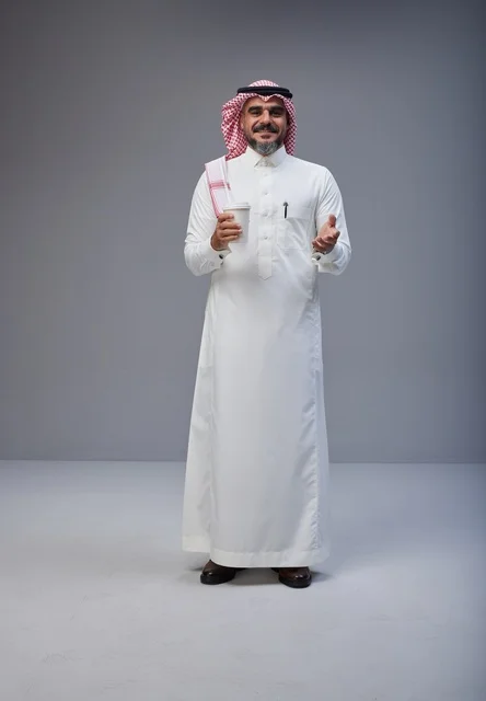 Saudi Man in Traditional Attire Holding Coffee in Studio