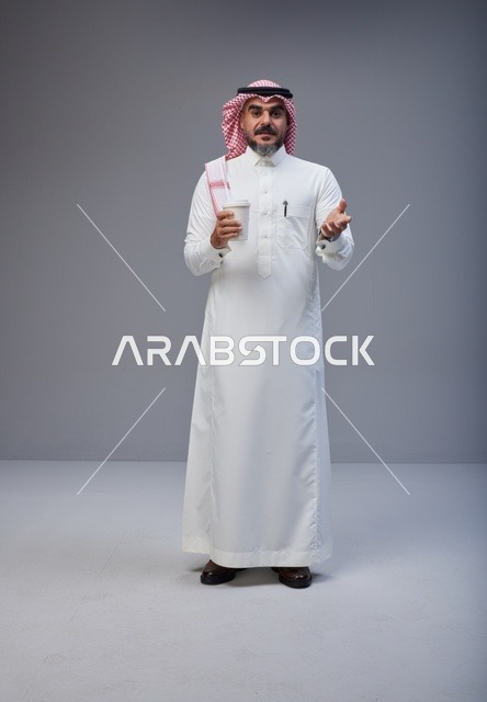 Saudi Man in Traditional Thobe Holding Coffee Cup
