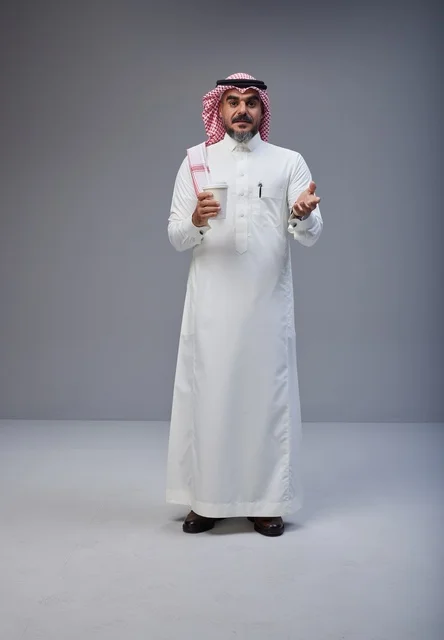 Saudi Man in Traditional Thobe Holding Coffee Cup Saudi Man in Traditional Thobe Holding Coffee Cup