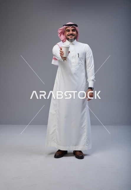 Saudi Man in Traditional Thobe Holding Coffee Cup