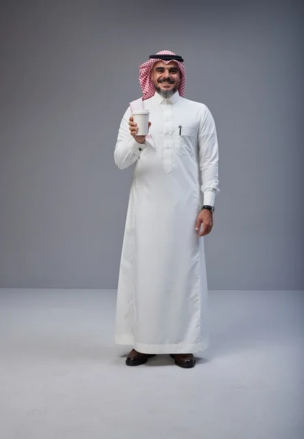 Saudi Man in Traditional Thobe Holding Coffee Cup