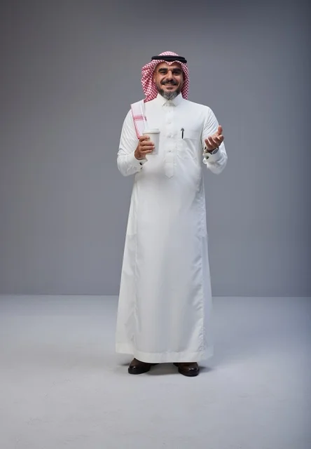 Saudi man in traditional attire holding a coffee cup