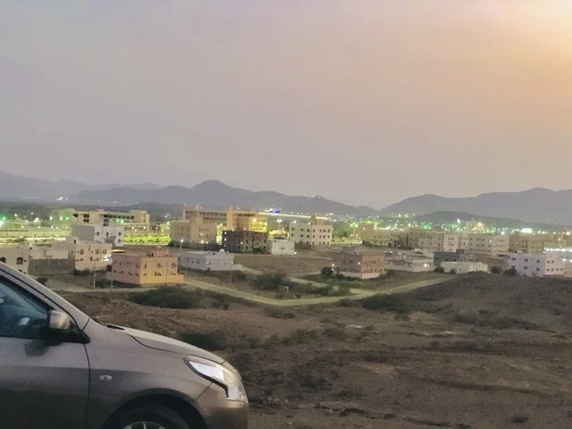 حي سكني وجبال في منطقة الباحة في السعودية وقت الغروب