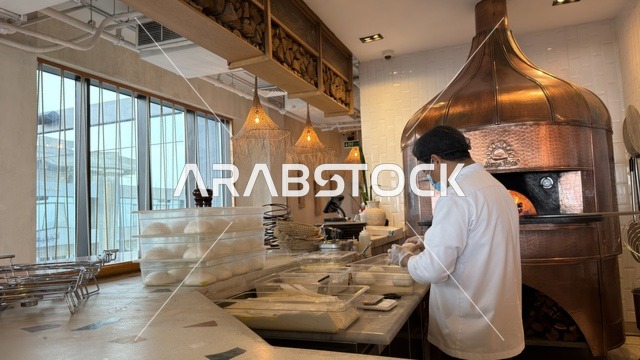 طباخ يحضر العجين في مخبز بمجمع مطل في الخبر