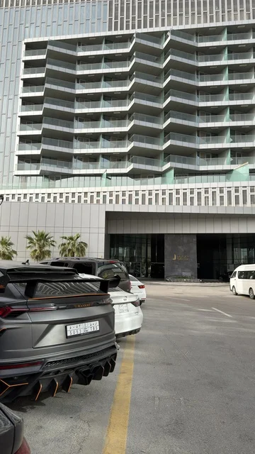 واجهة مجمع مطل الخبر مع سيارة فاخرة وعمارة حديثة