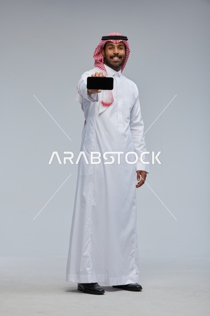 Saudi Man Holding Smartphone on Grey Background