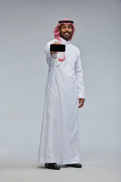 Saudi Man Holding Smartphone on Grey Background