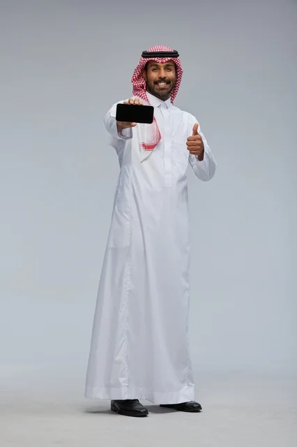 رجل سعودي يحمل هاتف ذكي مع علامة الإعجاب