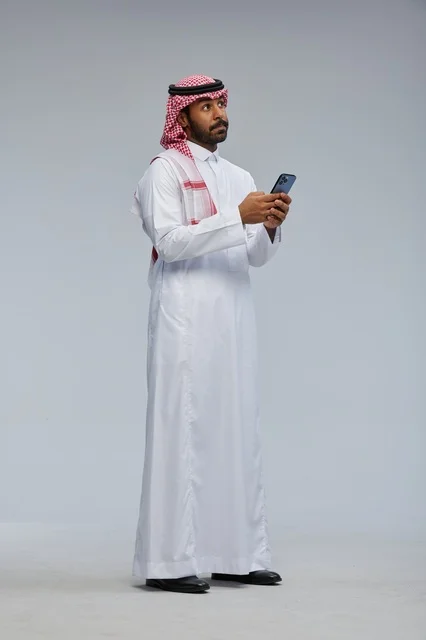 Saudi Man Using Smartphone in Traditional Dress Studio Shot