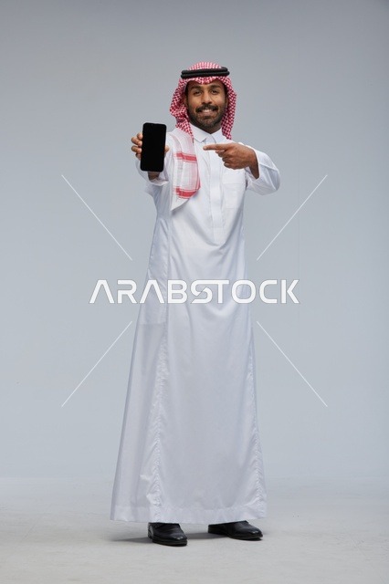 Saudi Man Pointing at Smartphone Screen in Studio
