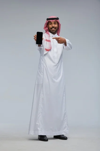 Saudi Man Pointing at Smartphone Screen in Studio