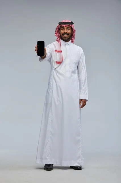 رجل سعودي يحمل هاتف ذكي في الاستوديو