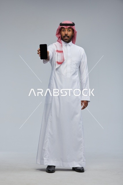 Saudi Man Holding Smartphone with Surprised Expression