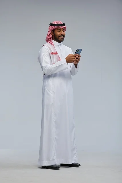 Saudi Man in Traditional Dress Using Smartphone
