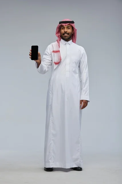 Saudi Man Holding Smartphone on Grey Studio Background