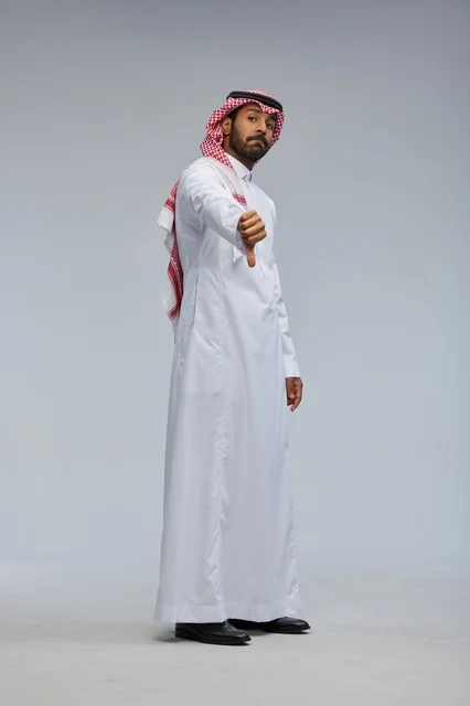 رجل سعودي بالزي التقليدي يشير بالإبهام للأسفل