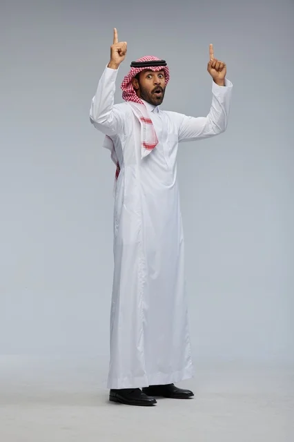 Surprised Saudi Man Pointing Up in Traditional Thobe