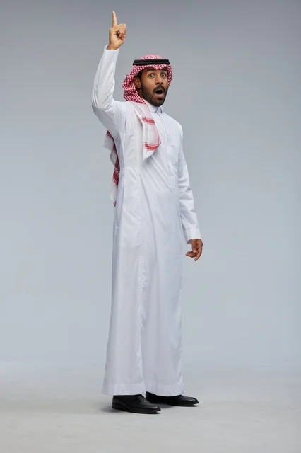 رجل سعودي بالزي التقليدي يشير للأعلى بدهشة