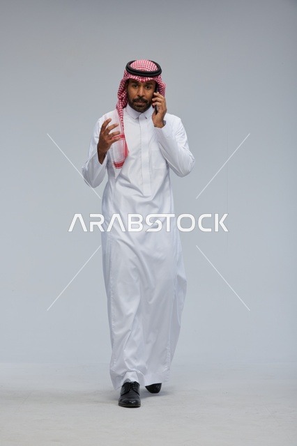 Saudi Man Talking on Smartphone in Studio Setting