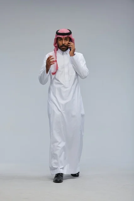 Saudi Man Talking on Smartphone on Grey Background