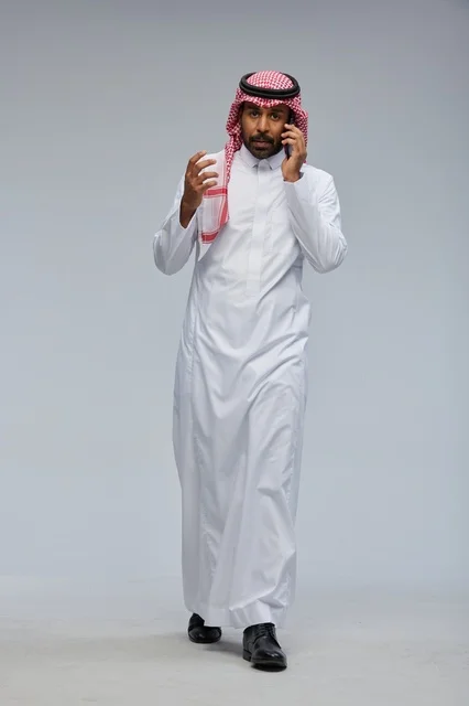 Saudi Man Walking While Talking on Smartphone in Studio