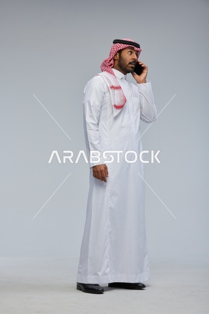 رجل سعودي يتحدث بالهاتف الذكي في الاستوديو