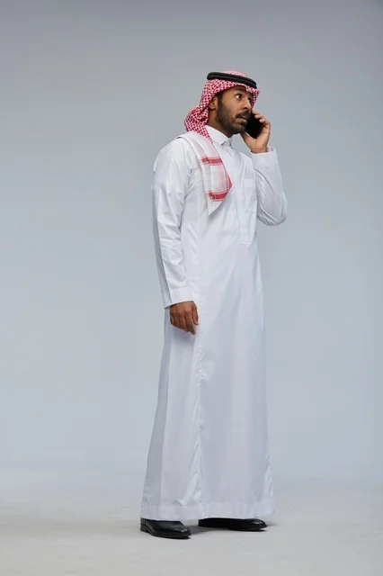 رجل سعودي يتحدث بالهاتف الذكي في الاستوديو