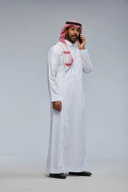 رجل سعودي يتحدث بالهاتف الذكي بالزي التقليدي