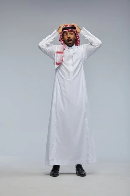 رجل سعودي بالزي التقليدي بتعبير وجه مصدوم في استوديو