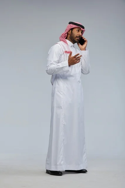 رجل سعودي يتحدث بالهاتف الذكي في الاستوديو