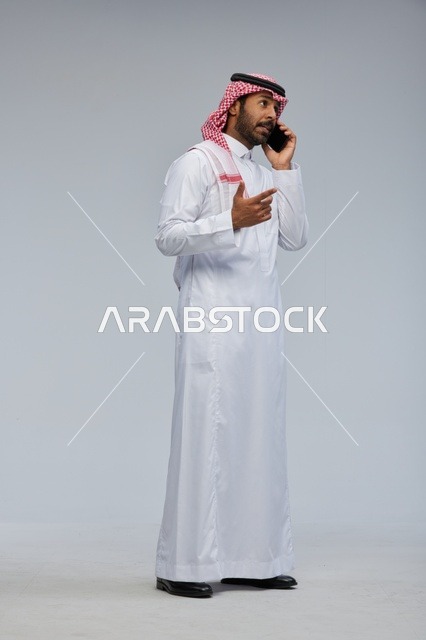 رجل سعودي يتحدث بالهاتف الذكي في الاستوديو