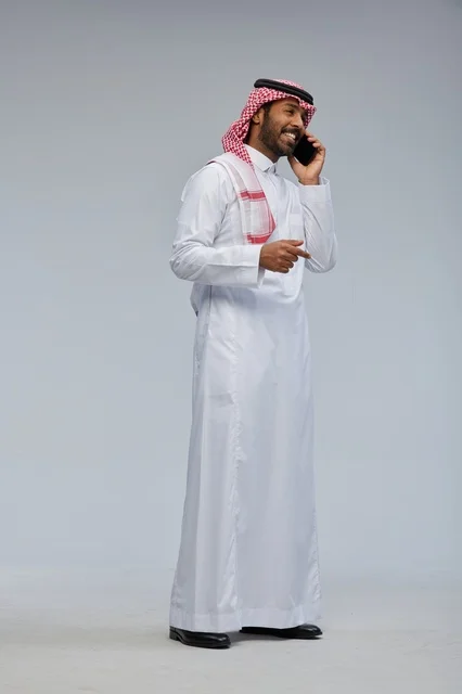 رجل سعودي يتحدث بالهاتف الذكي بالزي التقليدي
