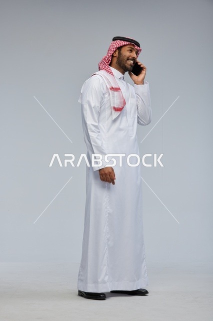 Saudi Man Talking on Smartphone in Traditional Thobe
