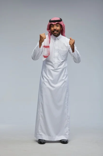 رجل سعودي في الاستوديو بالزي التقليدي يحتفل بالنجاح