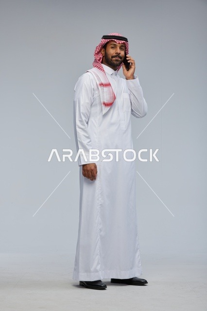 Saudi Man Talking on Smartphone in Traditional Thobe