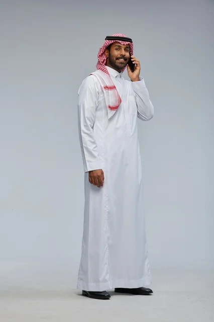 رجل سعودي يتحدث بالهاتف الذكي بالثوب التقليدي
