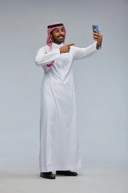 Saudi Man in Thobe Taking Selfie with Smartphone