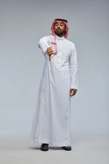 رجل سعودي بالزي التقليدي يقوم بحركة رفض بالإبهام