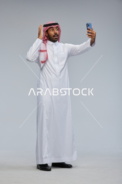 رجل سعودي يلتقط سيلفي بالهاتف ويتفاعل مع الكاميرا
