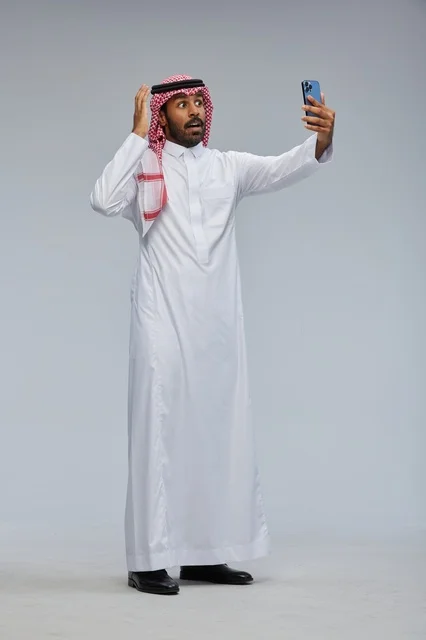 رجل سعودي يلتقط سيلفي بالهاتف ويتفاعل مع الكاميرا