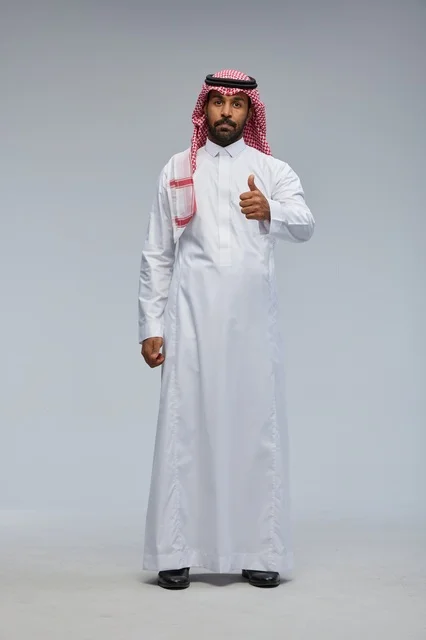 رجل سعودي بالزي التقليدي يشير بعلامة التأييد