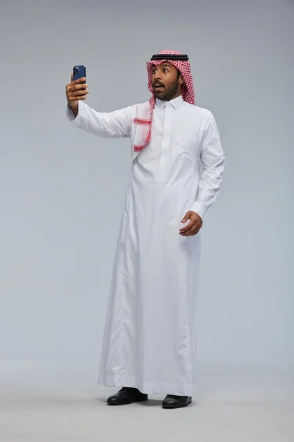 رجل سعودي يلتقط سيلفي بالهاتف في الاستوديو