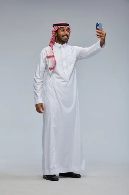 Saudi Man in Traditional Thobe Taking Smartphone Selfie