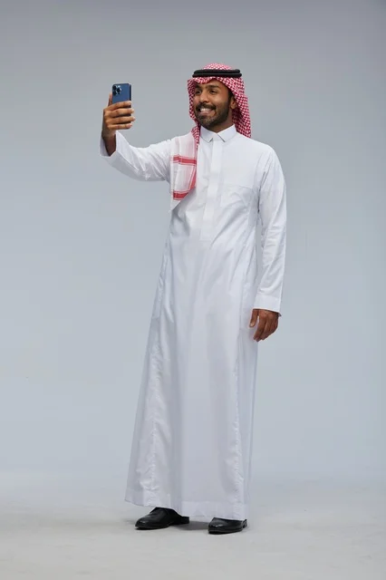Saudi man taking selfie with smartphone and interacting with the camera
