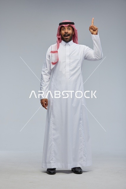 Saudi Man in Thobe Pointing Up with Surprised Face