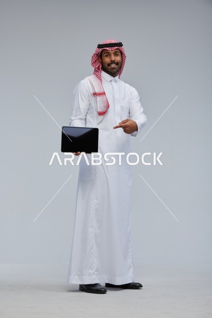 رجل سعودي يشير إلى جهاز لوحي في الاستوديو