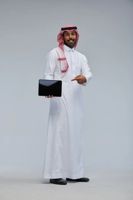 رجل سعودي يشير إلى جهاز لوحي في الاستوديو