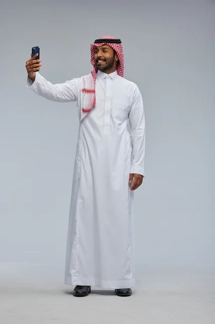 Saudi Man in Traditional Thobe Taking Smartphone Selfie